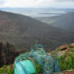 Telephone wire basket in progress, placed on lichen-covered rocks in the Meehan Ranges, Tasmania.
