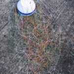 A telephone wire basket with over a metre long wires coiled around the frame, ready to start weaving