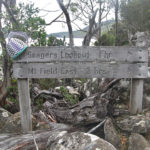 Wire basket in progress, poised on a bushwalking track sign that reads Seagers Lookout 1hr, Mt Field East 2 hrs