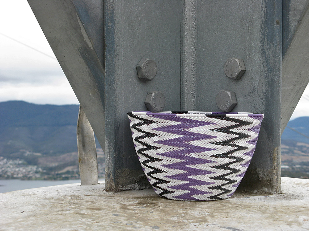 A close-up of the finished chevron-patterned basket placed on top of a concrete pylon on Mt Direction, near Hobart.