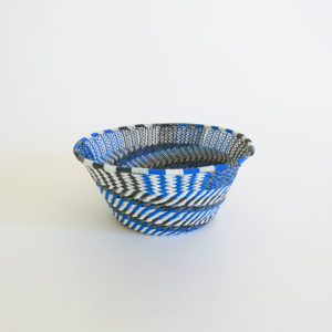 side view of a small blue, black, grey and white telephone wire basket
