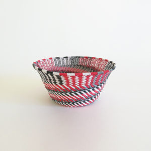 side view of a small red, black, grey and white telephone wire basket