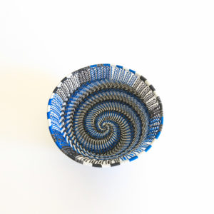 Top view showing the inside base of a small blue, black, grey and white telephone wire basket