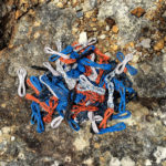 Coils of orange, blue, black and white telephone wire on a lichen-covered rock.